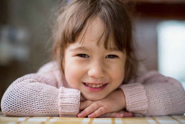 写真 小さな女の子は自然光の中で微笑んでいます。