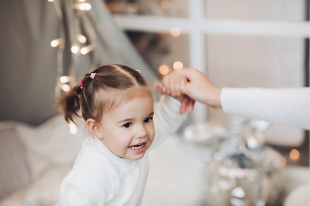 Little girl smiling at camera surrounded by garlands.