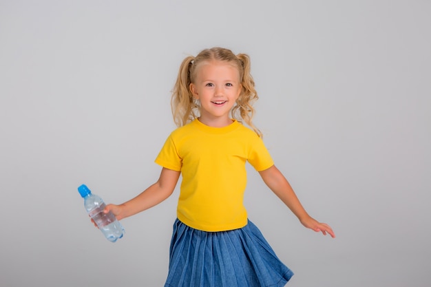 Bambina sorridente che tiene bottiglia d'acqua