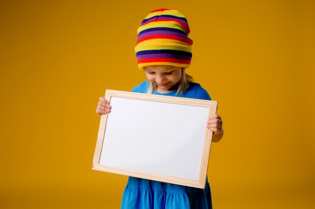 little girl smiling holding an empty drawing Board, space for text