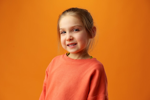 Little girl smiling portrait against yellow background