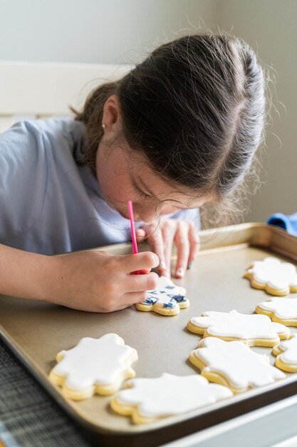 Little girl spells sorry on iced sugar cookies