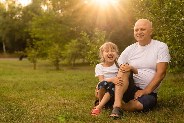 Little girl spending time with grandfather in the park.