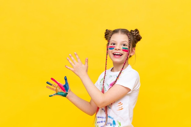 A little girl stained in multicolored paints is fooling around Children's creativity drawing Draw with your hands The art of creating paintings for schoolchildren