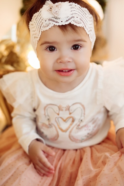 Little girl standing by the decorated Christmas tree