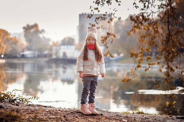 Photo little girl standing in front of lake