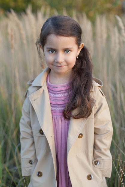 Una bambina sta in un campo mani piegate concetto di pace, speranza, sogni,