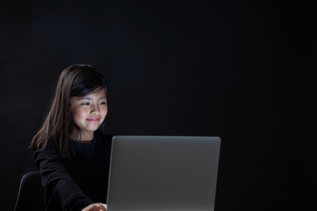 little girl staring on laptop at night