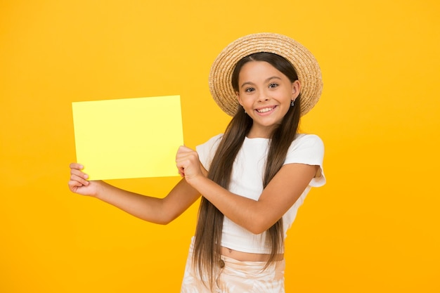 Маленькая девочка в соломенной шляпе представляет плакат с рекламой, копией пространства, концепция списка летних ведер