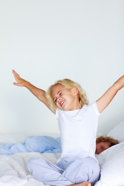 Little girl stretching in bed