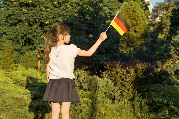 Photo little girl student holding a flag of germany