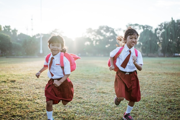 Little girl student running together while going to their school