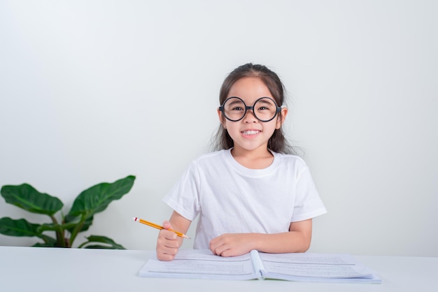 Little girl study doing test in primary school children writing notes in classroom concept