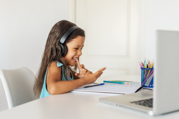 Little girl studying in front of the laptop