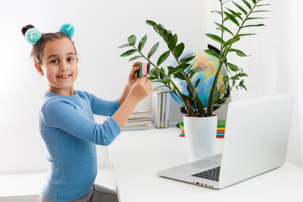 little girl studying nerd on laptop online