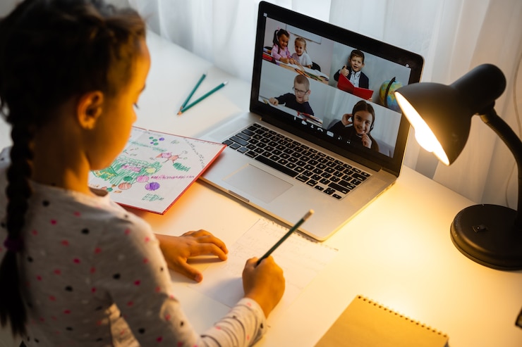 Photo little girl studying online using her laptop at home