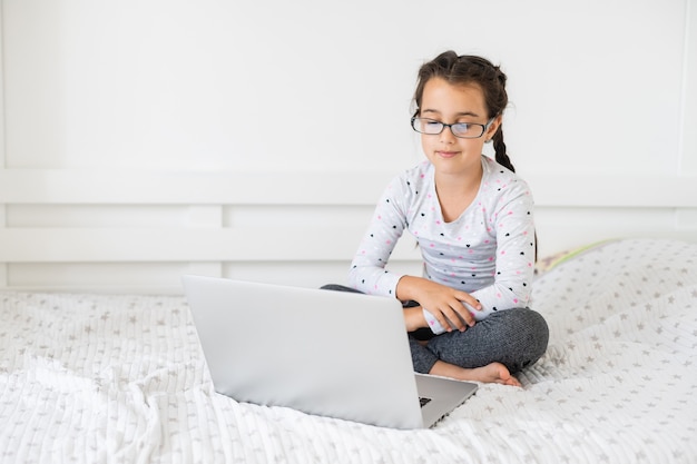 집에서 노트북을 사용하여 온라인으로 공부하는 어린 소녀