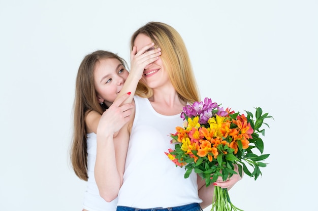 alstroemeria 꽃의 무리와 함께 그녀의 엄마를 놀라게하는 어린 소녀