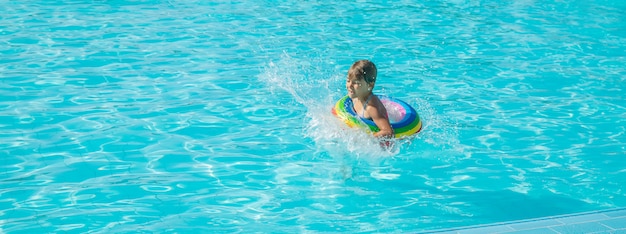Маленькая девочка плавает в бассейне