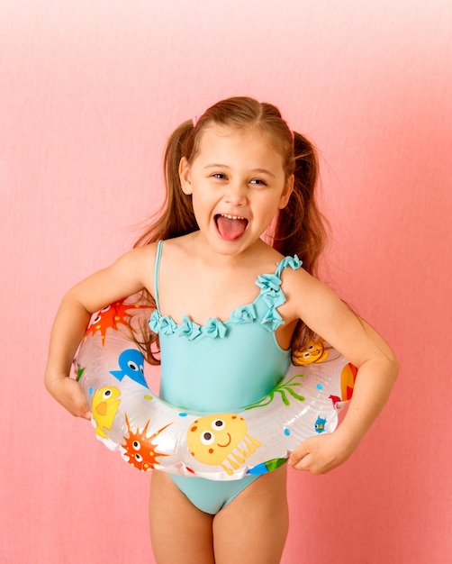 Photo little girl in a swimsuit on a pink background