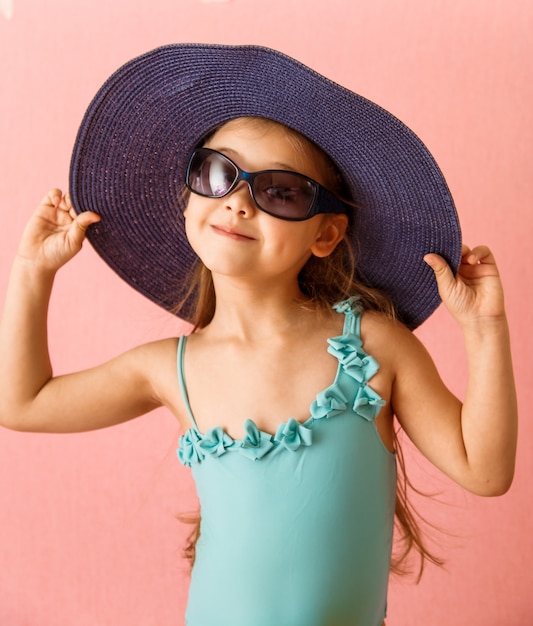 Little girl in a swimsuit on a pink background