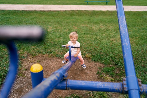 Bambina che oscilla su un'oscillazione dell'equilibrio nel parco giochi