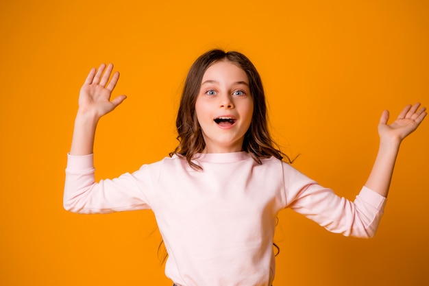 Little girl takes a pleasant surprise and raises her hands