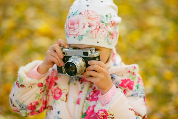 Bambina che prende immagine facendo uso della macchina da presa d'annata