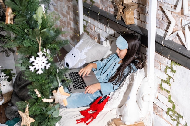 Little girl talking and happy New Year on a laptop. Online congratulations.