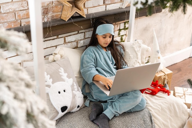 Little girl talking and happy New Year on a laptop. Online congratulations.