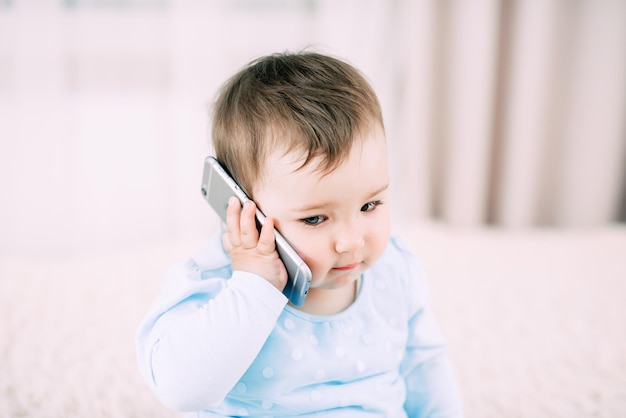 A little girl talking on a smartphone smiling and happy very sweet