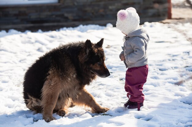 Little girl talking with her dog on winter walk