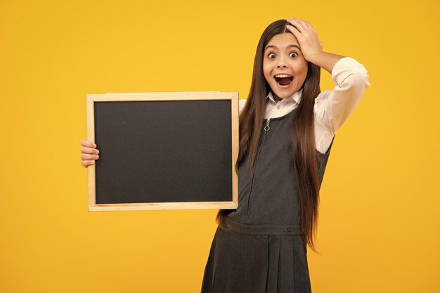 Little girl teen with blackboards teenager school girl hold blackboard for copy space school sale excited face cheerful emotions of teenager girl