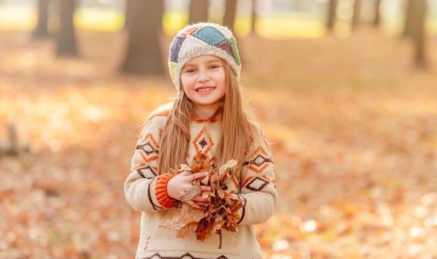 Little girl throwing up leaves