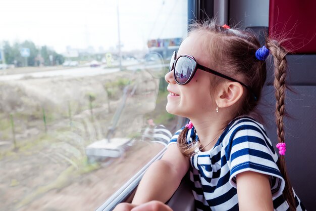 Little girl on the train looks out the window