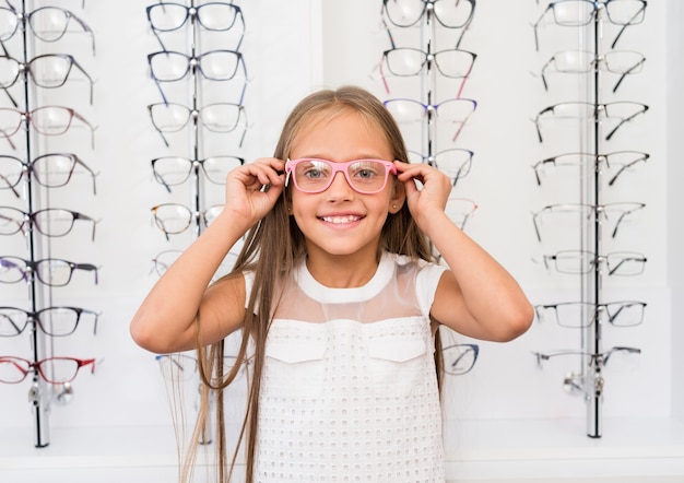 Little girl trying on glasses at the optical store