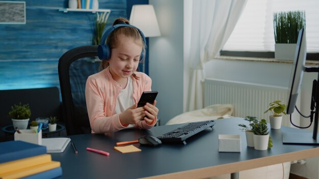 Little girl using smartphone for lessons on video call