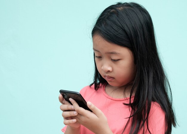 Little girl using smartphone in studio