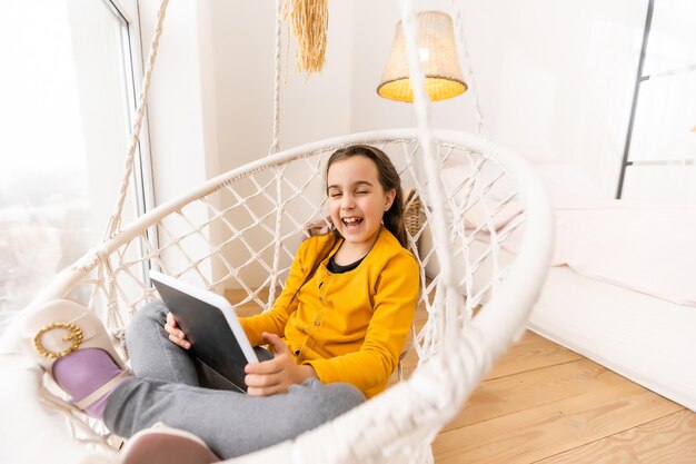 Little girl using tablet computer at home.