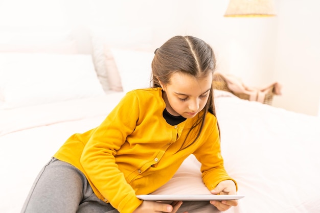 Little girl using tablet computer at home.