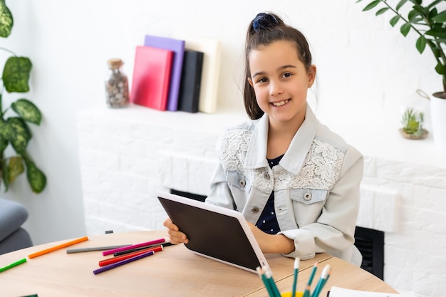 Bambina che utilizza la chat video sul tablet a casa. spazio per il testo