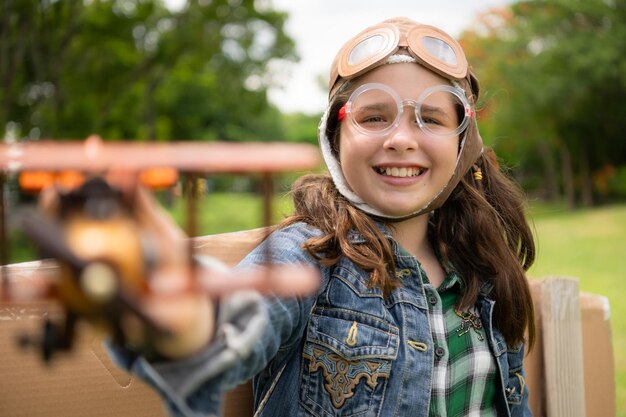 A little girl on vacation at the park with a pilot outfit and flying equipment Run around