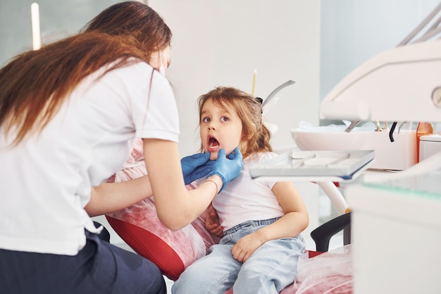 Little girl visiting dentist in clinic Conception of stomatology