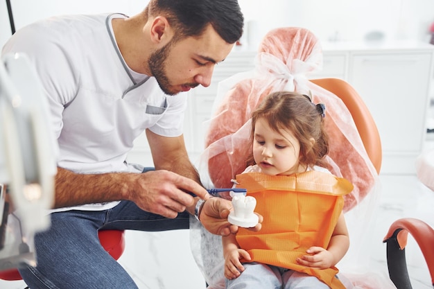 Photo little girl visiting male dentist in clinic conception of stomatology