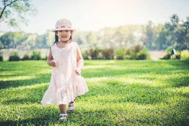 Little girl walking alone in a park or forest