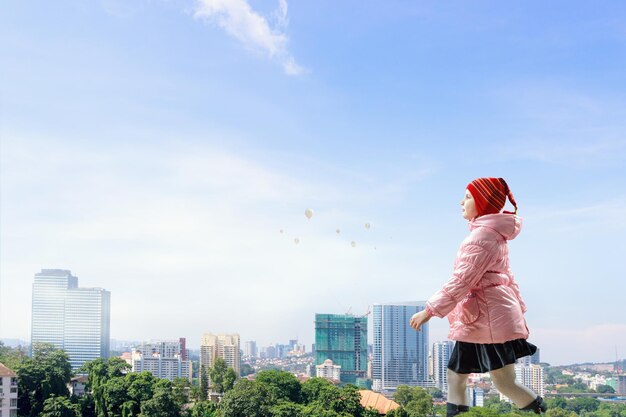 Little girl walking with city at background. Mixed media