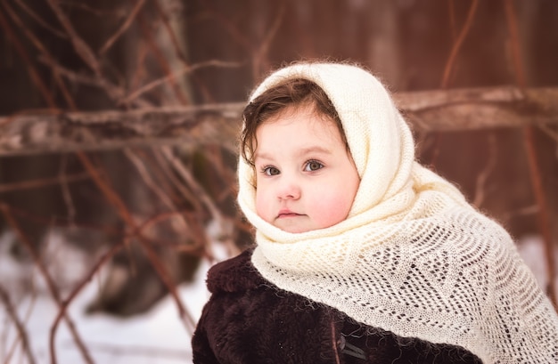 Little girl walks in nature in winter. Winter clothing