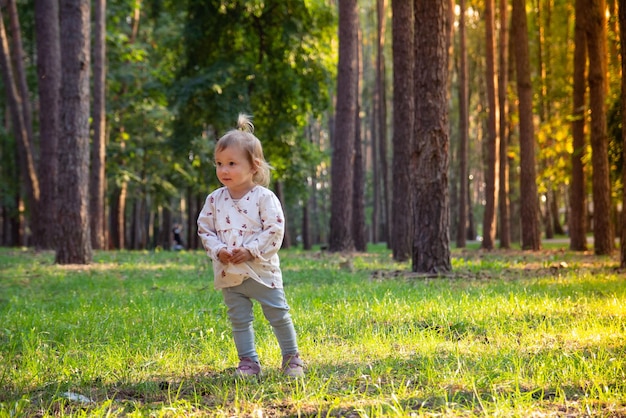 Little girl walks in a pine forest