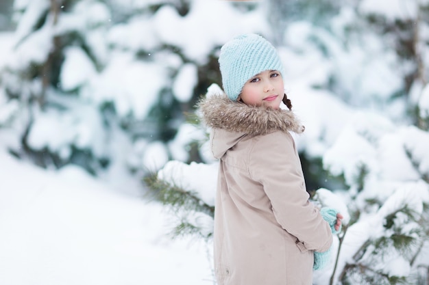 A little girl walks in the winter forest