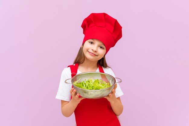 A little girl wants to cook a new dish of fresh salad on an isolated background